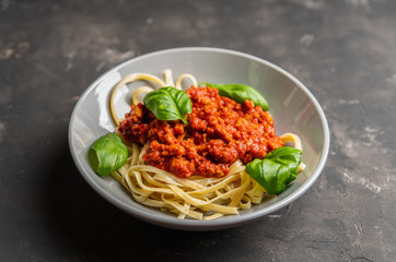 Wall Mural - Traditional pasta bolognese with beef and tomatoes the rustic background. Selective focus.