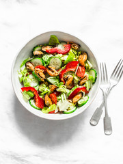 Wall Mural - Salad with fresh vegetables and canned mussels on a light background, top view. Delicious healthy diet food