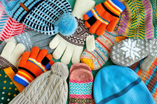 A Lot Of Hats, Gloves, Mittens. Warm Clothes In The Form Of Knitted Hats, Mittens, Gloves, Scarves For The Cold Seasons. Multi-colored Clothes For Autumn And Winter.