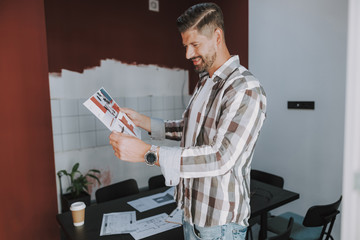 Happy young man is looking on project plan of home