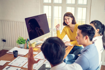 Wall Mural - group of young asian designer in smart casual wear talking and development ux app on mobile phone du