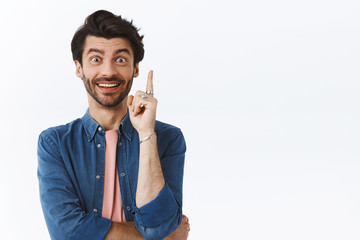 Wall Mural - Got excellent idea. Creative good-looking caucasian bearded man, raise one finger and smiling astonished as have something say, give good suggestion during meeting with coworkers, white background