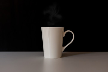 Coffee in a white cup on the table and dark background