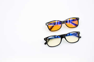 Two blue light blocking glasses (yellow and orange lenses) isolated on white background