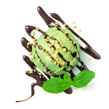 Top View Of Pistachio Ice Cream Ball With Chocolate Syrup, Wallnuts And Mint Leaf Isolated On White Background