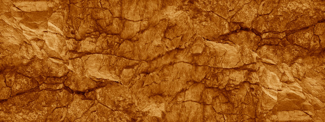 Wall Mural - brown orange rock background. wide banner. toned cracked mountains surface texture. close-up. stone 