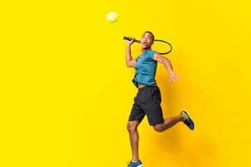 Wall Mural - Afro American tennis player man over isolated yellow background