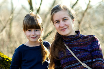 Wall Mural - Young mom and her daughter girl together outdoors.