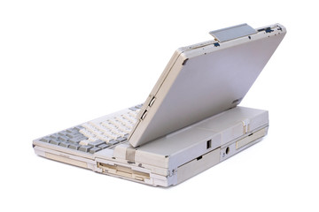 Old laptop computer or portable personal computer isolated on white background with clipping path. Side view. Vintage 90s technology concept.