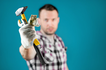 man hands out tools and crumpled money to the camera as a symbol of hard work