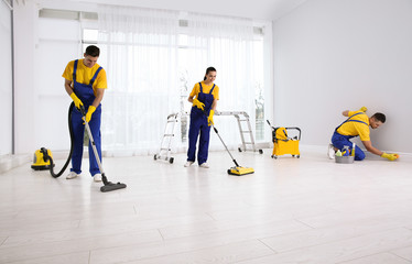 Canvas Print - Team of professional janitors cleaning room after renovation