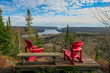 Two iconic red chairs facing the St Maurice river, Mauricie national park