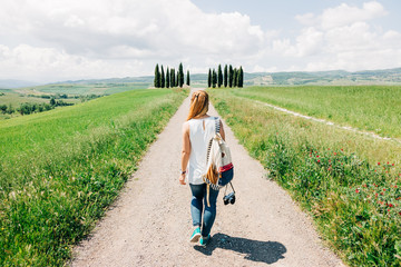 young female traveler walking in tuscany countryside