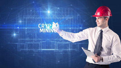 Handsome architect with helmet drawing CRYPTO MINING inscription, new technology concept