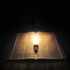 Wall Mural - Light bulb lighting up an open bible