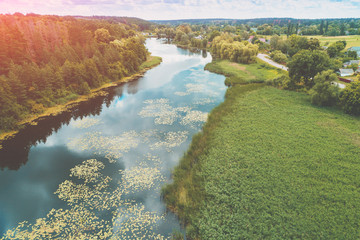 Wall Mural - Top view of a river in the countryside on a sunny day. Nature landscape with a beautiful cloudy sky. In summer