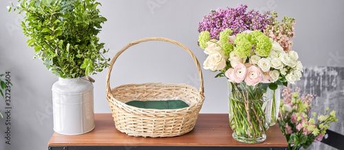 Education in the school of floristry. Master class on making bouquets. Summer bouquet in a wicker basket.. Learning flower arranging, making beautiful bouquets with your own hands. Flowers delivery