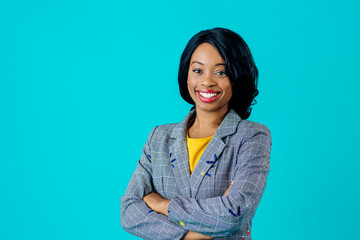 portrait of a happy smiling young woman in business jacket with arms crossed isolated on blue