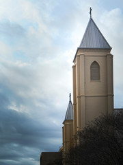 Church steeple rises through the stormy skies.