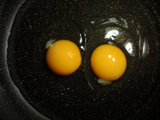 Process of frying eggs. A Fried-Eggs is fried in a frying pan. Omelette of two eggs. First stage of cooking