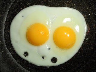 Process of frying eggs. A Fried-Eggs is fried in a frying pan. Omelette of two eggs. Almost ready