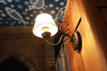 Lighted sconce on wooden cabinet