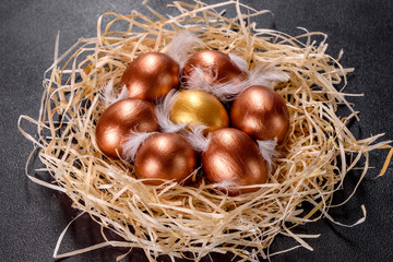 Easter golden eggs in the nest, preparation for the holiday