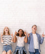© Prostock-studio - Teen boy and two girls looking up at empty space