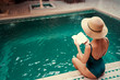 © Loginova - Retreat and vacation. Beautiful young woman reading book in spa swimming pool.