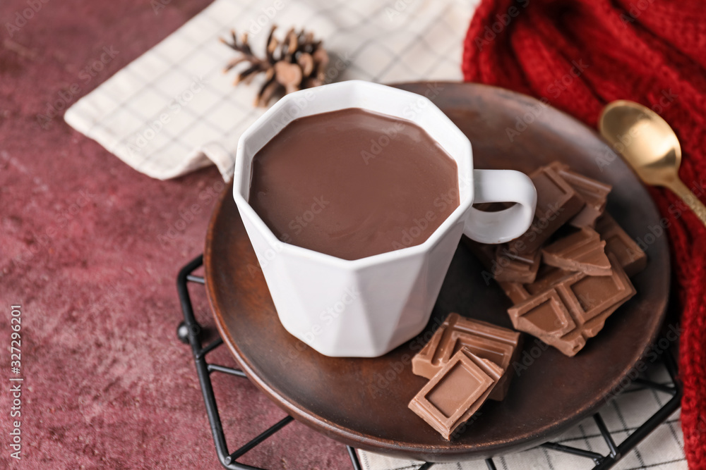 Cup of hot chocolate on color background