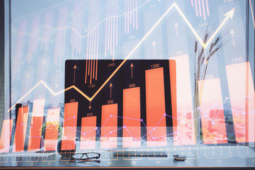 Stock market chart hologram drawn on personal computer background. Double exposure. Concept of investment.