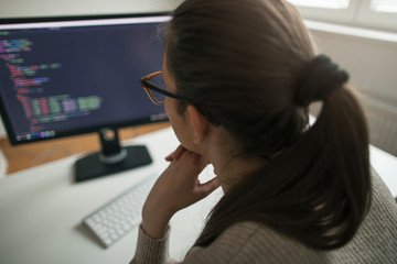 rear view of woman working on desktop pc