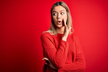 Sticker - Young beautiful blonde woman wearing casual sweater over red isolated background hand on mouth telling secret rumor, whispering malicious talk conversation