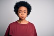 © Krakenimages.com - Young beautiful African American afro woman with curly hair wearing casual t-shirt standing puffing cheeks with funny face. Mouth inflated with air, crazy expression.