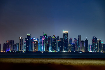 Wall Mural - Vibrant Skyline of Doha at Night as seen from the opposite side of the capital city bay sunset