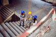 © Dusan Petkovic - Group of successful young innovative architects climbing the stairs and talking about project. Building in construction process interior.