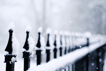 Snow On Spikes Of A Wrought Iron Fence
