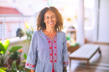 Middle age beautiful woman smiling happy and confident standing with a smile on face at terrace