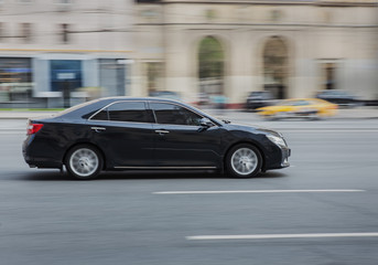 Canvas Print - Car moves on a city street.