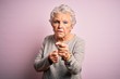 © Krakenimages.com - Senior beautiful woman wearing casual t-shirt standing over isolated pink background Ready to fight with fist defense gesture, angry and upset face, afraid of problem