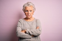 Senior Beautiful Woman Wearing Casual T-shirt Standing Over Isolated Pink Background Skeptic And Nervous, Disapproving Expression On Face With Crossed Arms. Negative Person.