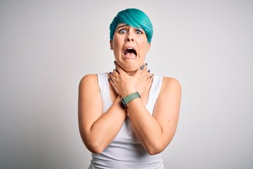 Young beautiful woman with blue fashion hair wearing casual t-shirt over white background shouting suffocate because painful strangle. Health problem. Asphyxiate and suicide concept.