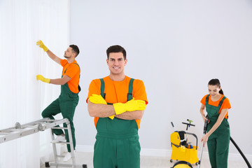 Canvas Print - Team of professional janitors cleaning room after renovation