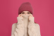 © New Africa - Young woman wearing warm sweater and hat on crimson background. Winter season