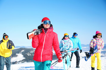 Sticker - Young woman with ski at resort. Winter vacation