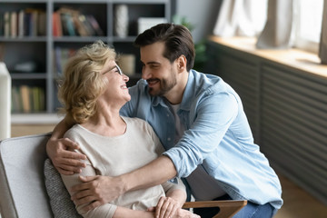 Happy senior mom and adult son enjoy time talking