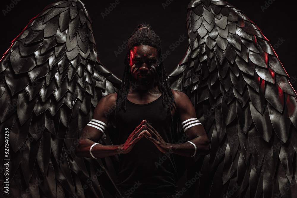 portrait of strong dark angel isolated over black background, young ...