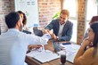© Krakenimages.com - Group of business workers smiling happy and confident. Working together with smile on face shaking hands at the office