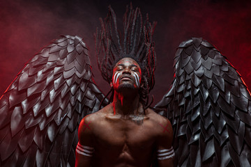 portrait of reckless dark angel with strong muscles, having athletic body, african man in the flesh of dark angel illustrate falling from heaven, angel wants to give people the right decision