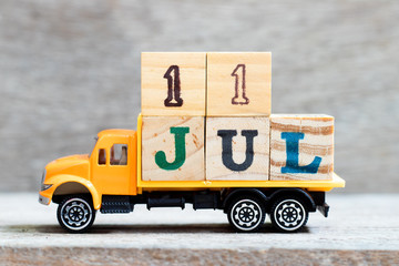 Wall Mural - Truck hold letter block in word 11jul on wood background (Concept for date 11 month July)